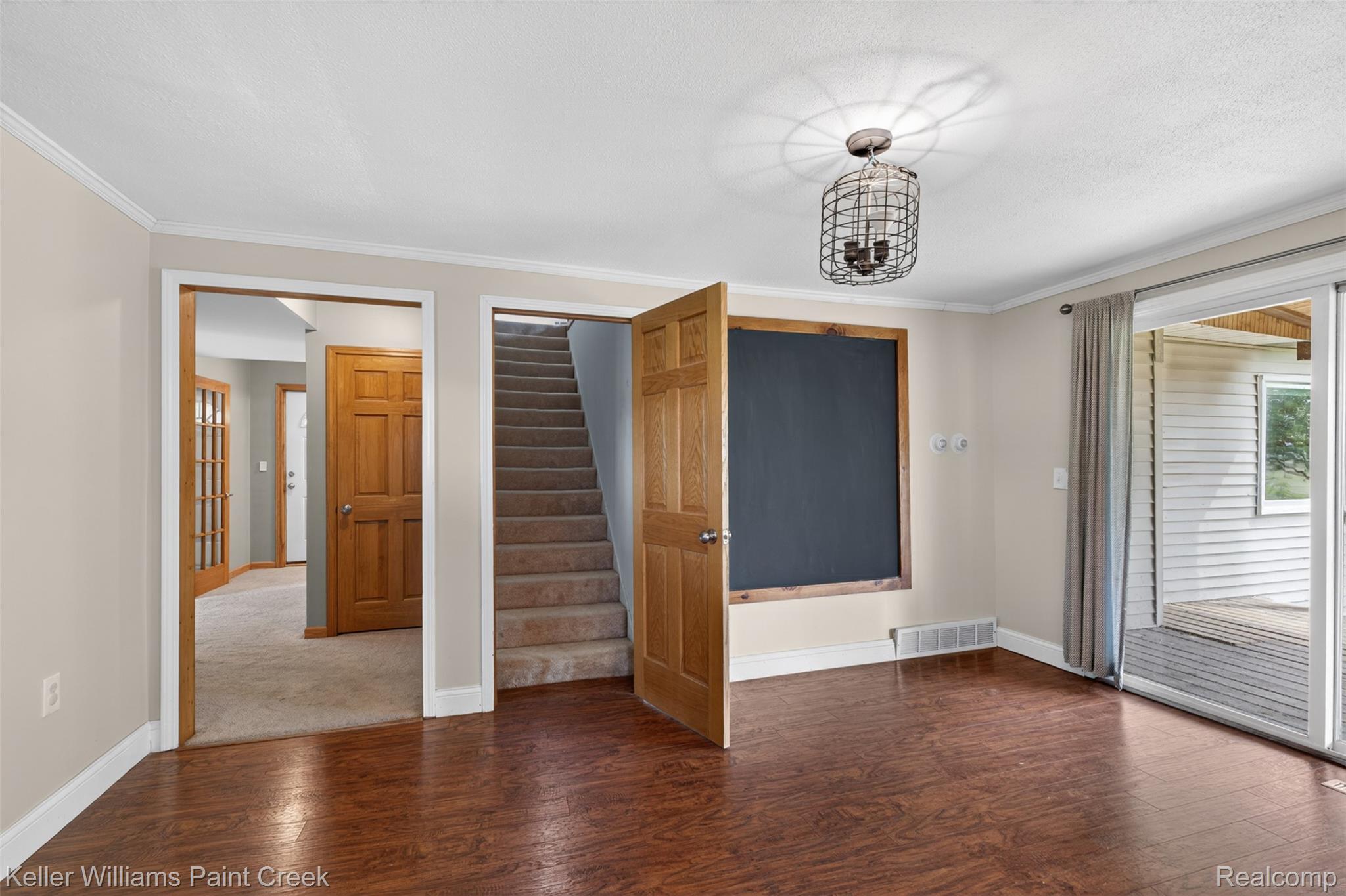 18125 Nelson Road St. Charles, MI 48655 - Photo 30 of 63 Unfurnished bedroom featuring access to exterior, dark wood-type flooring, ornamental molding, and suspended lighting