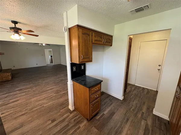 an empty room with wooden floor and cabinet