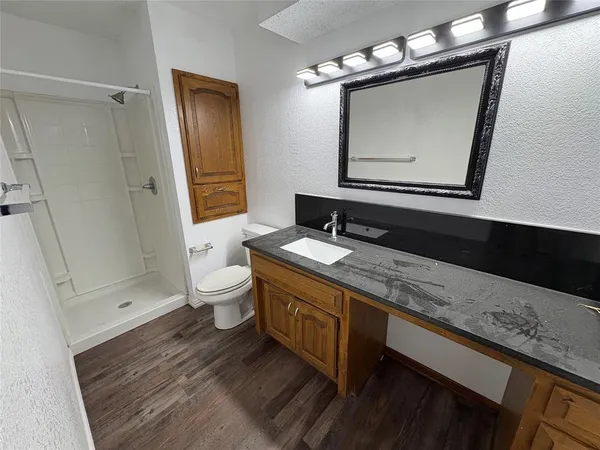 a bathroom with a granite countertop sink a toilet and a mirror
