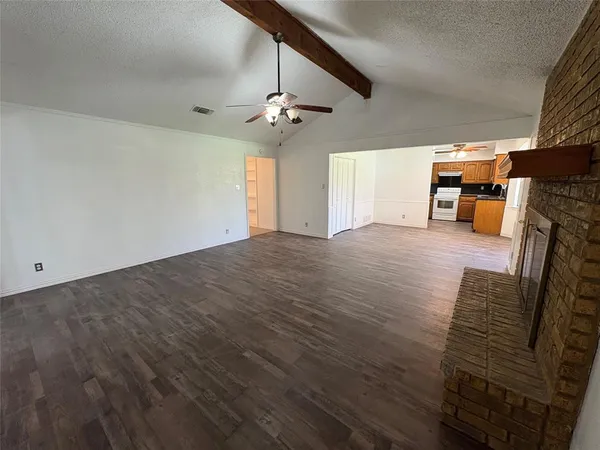 a view of a livingroom with wooden floor and a ceiling fan
