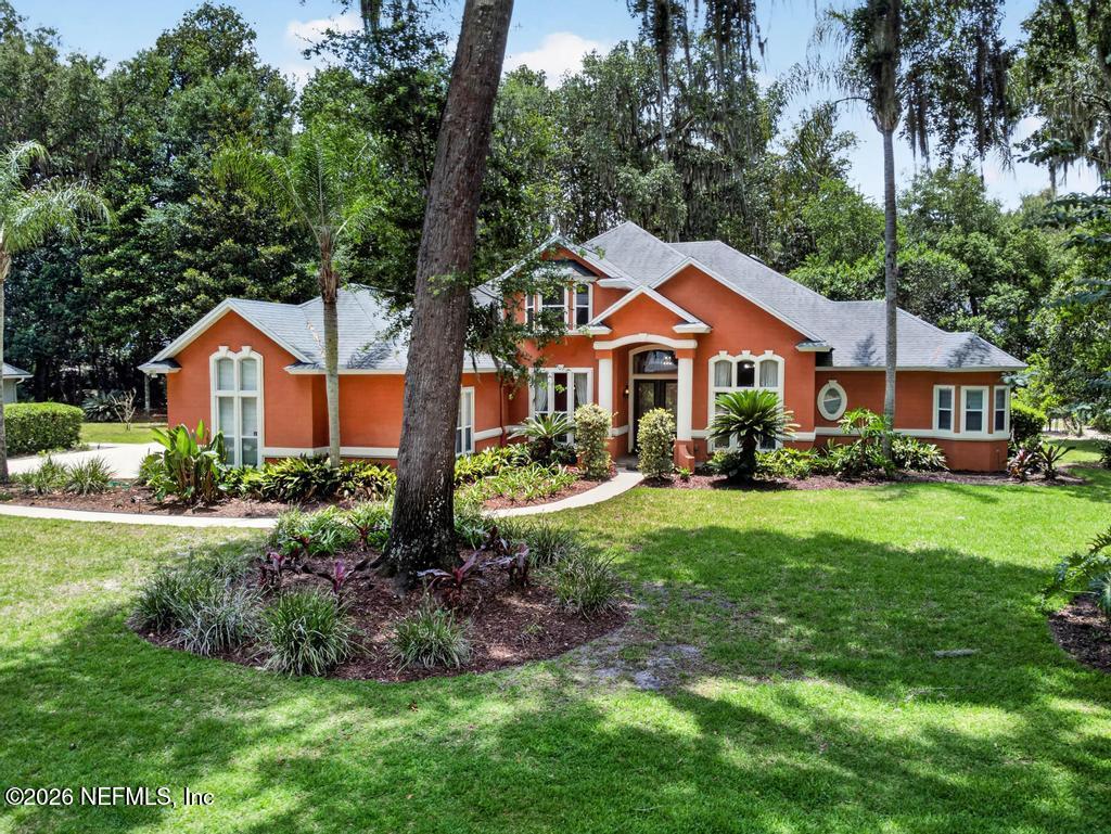 a front view of a house with a yard and trees