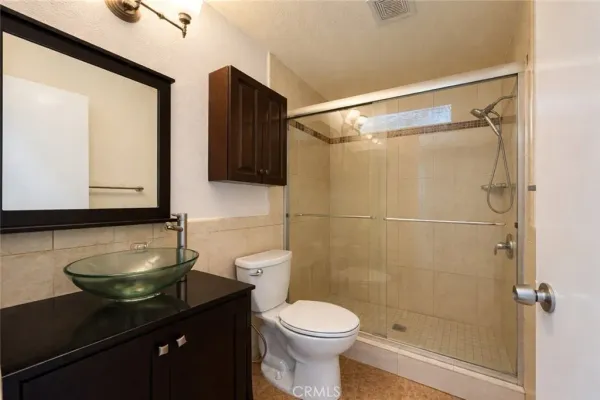 a bathroom with a granite countertop sink toilet and shower