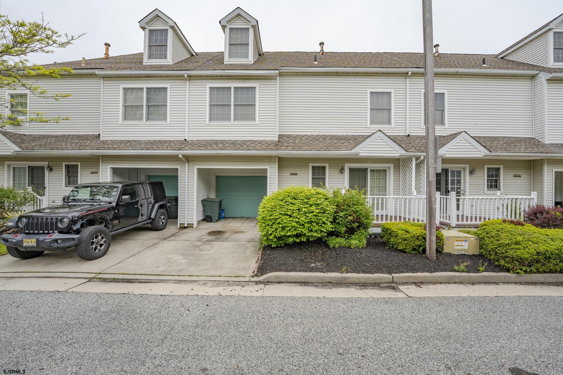 a view of multiple houses with a yard and plants