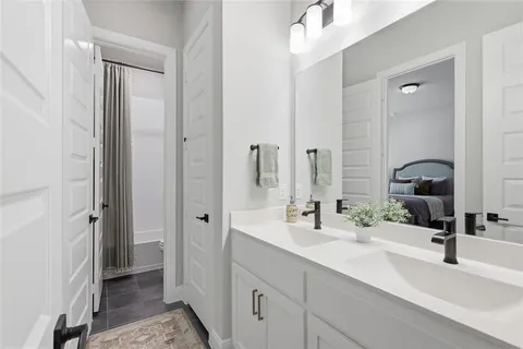 a bathroom with a double vanity sink mirror and shower