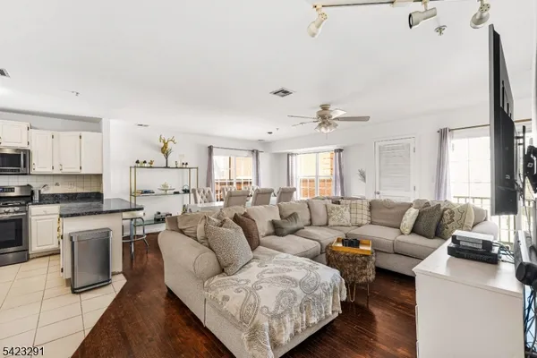 a living room with furniture kitchen and a flat screen tv