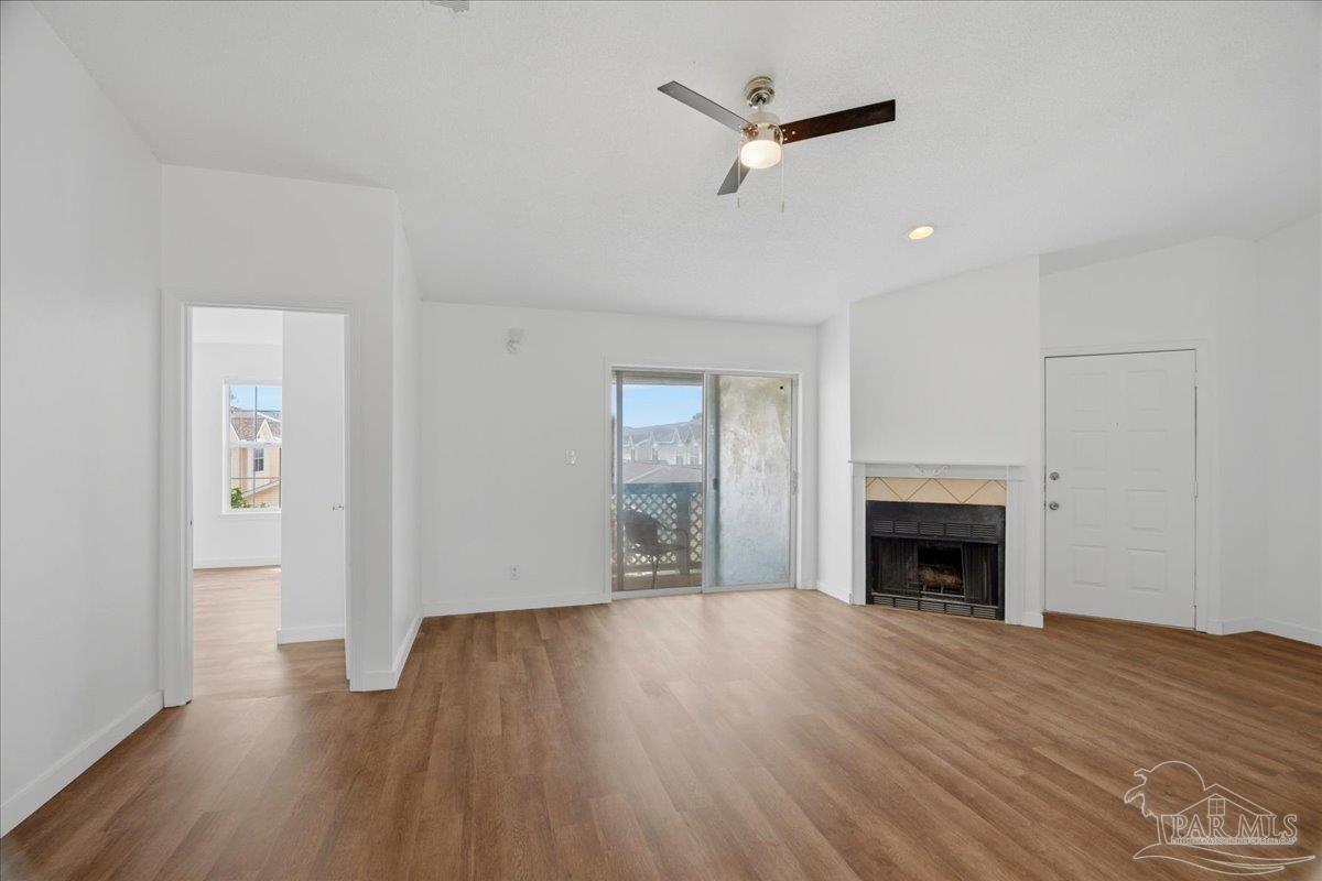 601 East Burgess Road, Unit C6 Pensacola, FL 32504 - Photo 34 of 39 an empty room with wooden floor fireplace and windows
