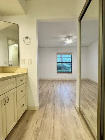 a view of empty room with wooden floor and fan