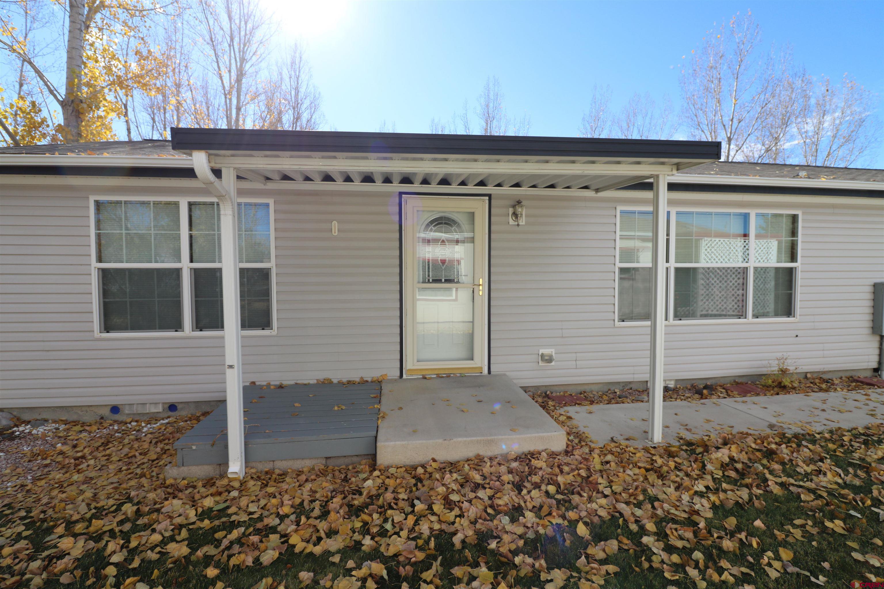901 6530 Road, Unit 1302 Montrose, CO 81401 - Photo 1 of 25 a view of a blue house with a door
