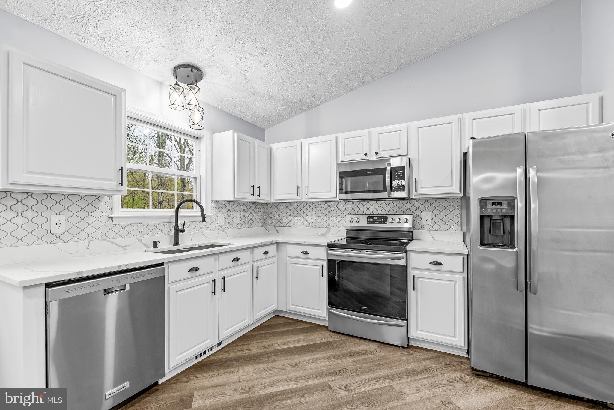 307 Red Cloud Road Lusby, MD 20657 - Photo 11 of 35 a kitchen with a sink cabinets stainless steel appliances and a window