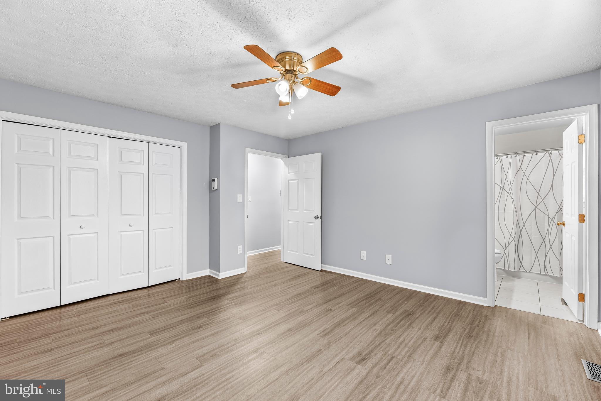 307 Red Cloud Road Lusby, MD 20657 - Photo 16 of 35 a view of an empty room with wooden floor and a ceiling fan