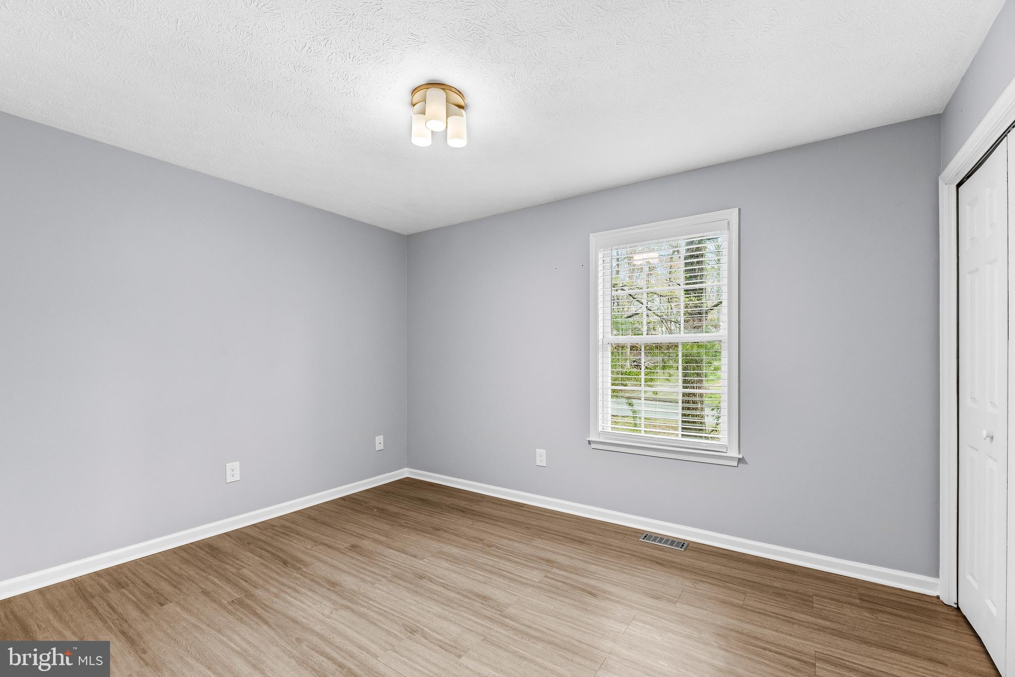 307 Red Cloud Road Lusby, MD 20657 - Photo 19 of 35 wooden floor in an empty room with a window
