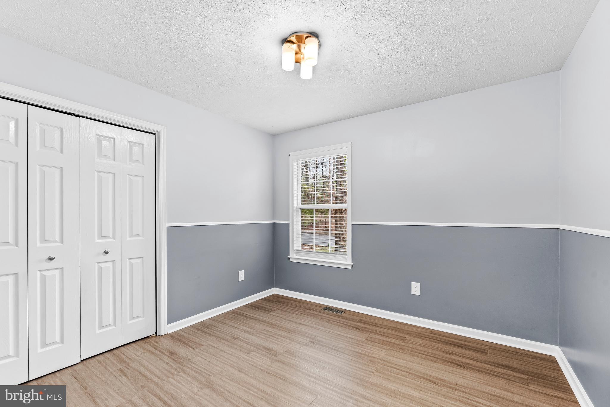 307 Red Cloud Road Lusby, MD 20657 - Photo 20 of 35 an empty room with wooden floor closet and windows