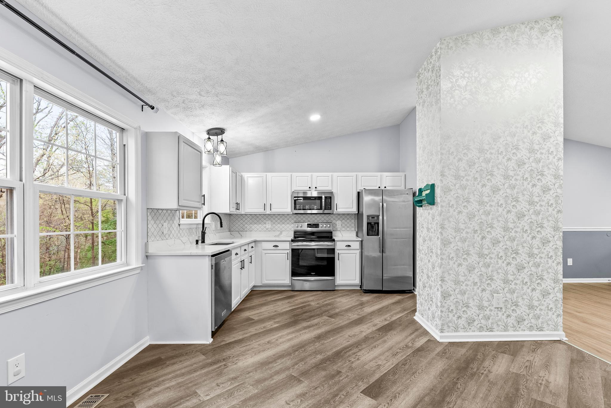 307 Red Cloud Road Lusby, MD 20657 - Photo 6 of 35 a kitchen with stainless steel appliances a refrigerator sink and stove