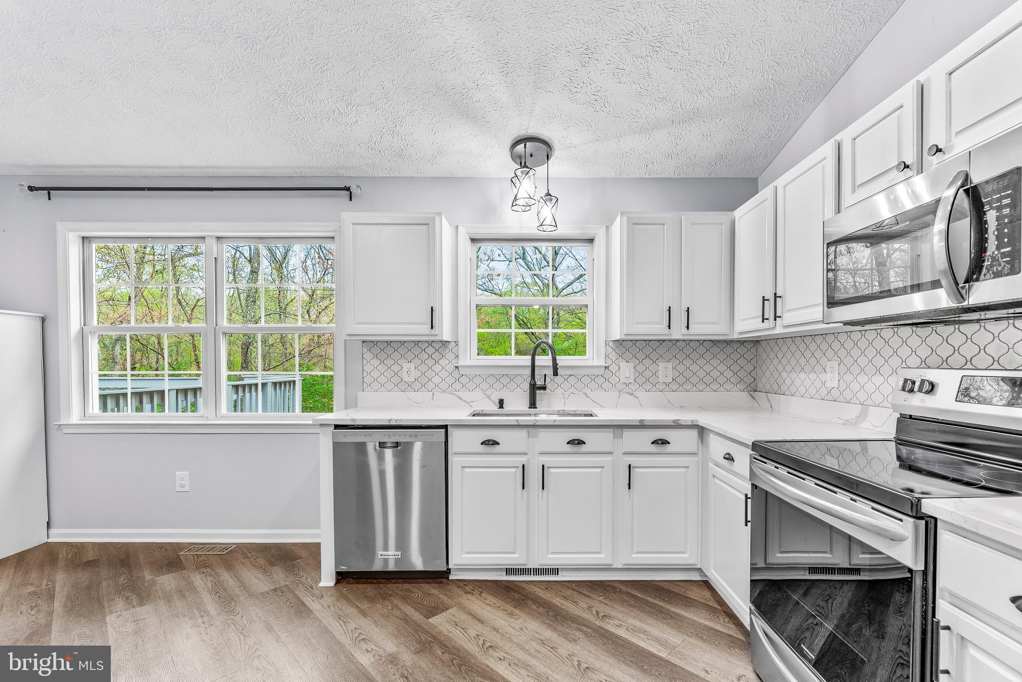 307 Red Cloud Road Lusby, MD 20657 - Photo 9 of 35 a kitchen with stainless steel appliances white cabinets a sink and a stove