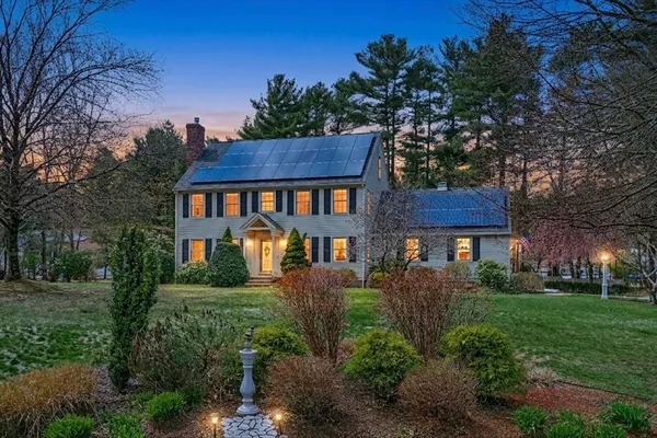 a front view of a house with a yard and trees