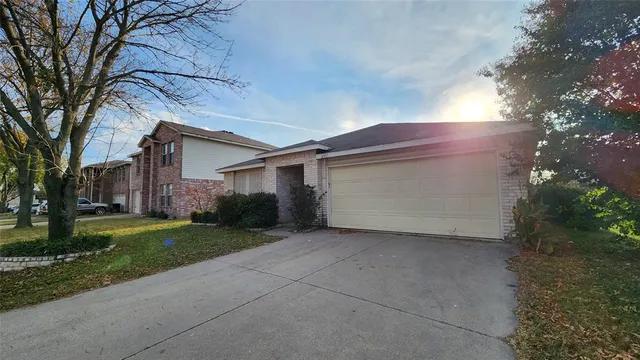 a view of a house with a large tree and a yard