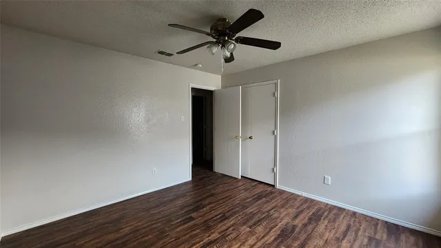 a view of room with wooden floor and ceiling fan