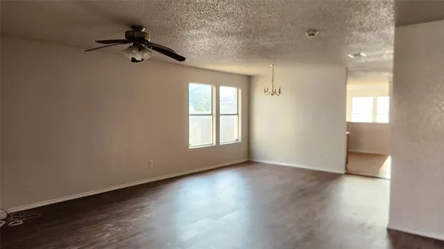 an empty room with a wooden floor and windows