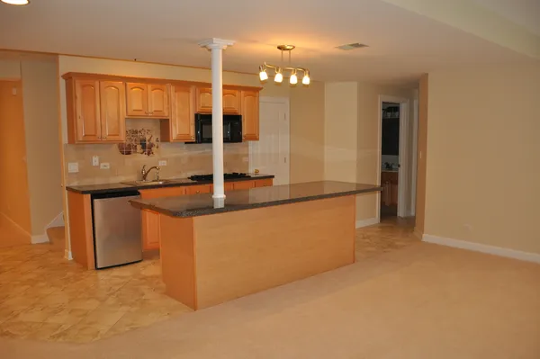 a kitchen with stainless steel appliances granite countertop a sink and a large window