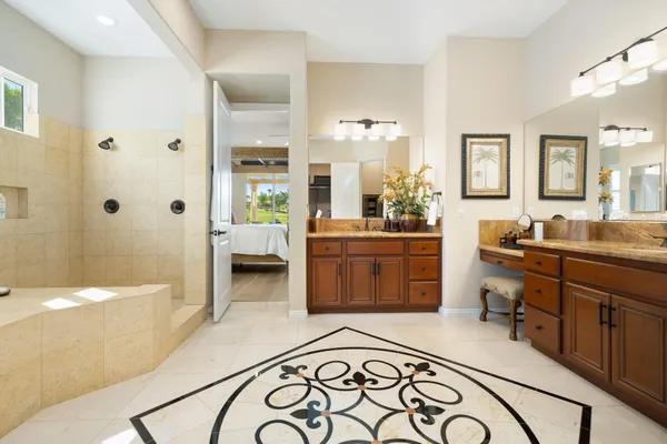 a en suite bathroom with a double vanity sink a mirror and a bathtub