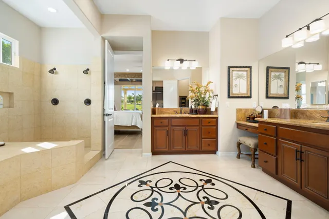 a en suite bathroom with a double vanity sink a mirror and a bathtub