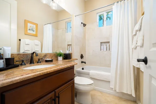 a bathroom with a granite countertop sink a toilet and shower