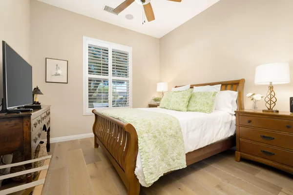 a bedroom with a bed and a flat tv screen on dresser