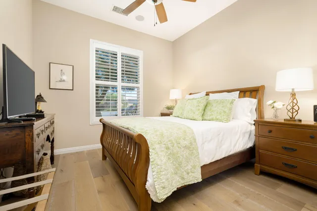 a bedroom with a bed and a flat tv screen on dresser