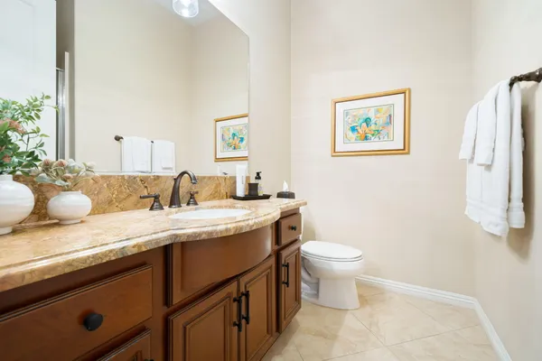 a bathroom with a granite countertop sink mirror and toilet