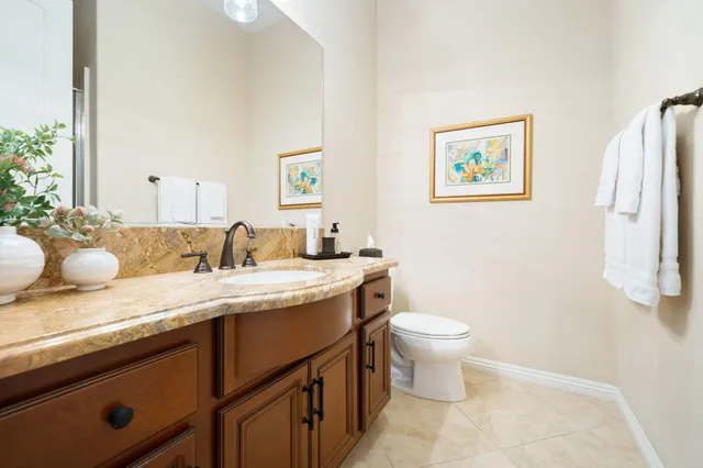 a bathroom with a granite countertop sink mirror and toilet