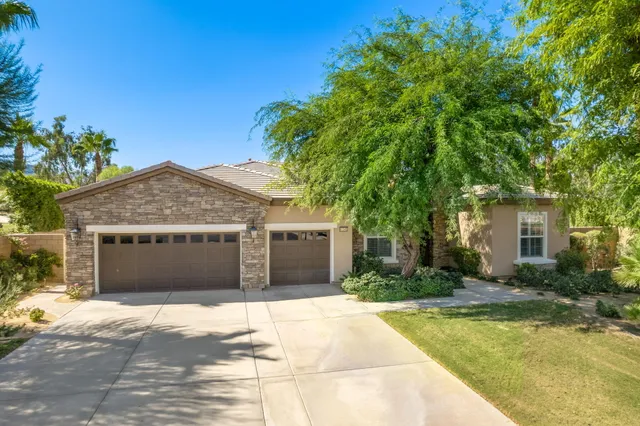 a front view of a house with a garden and garage