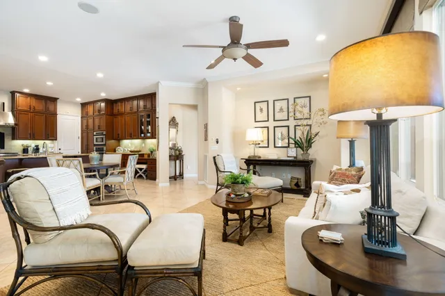 a living room with furniture kitchen view and a chandelier