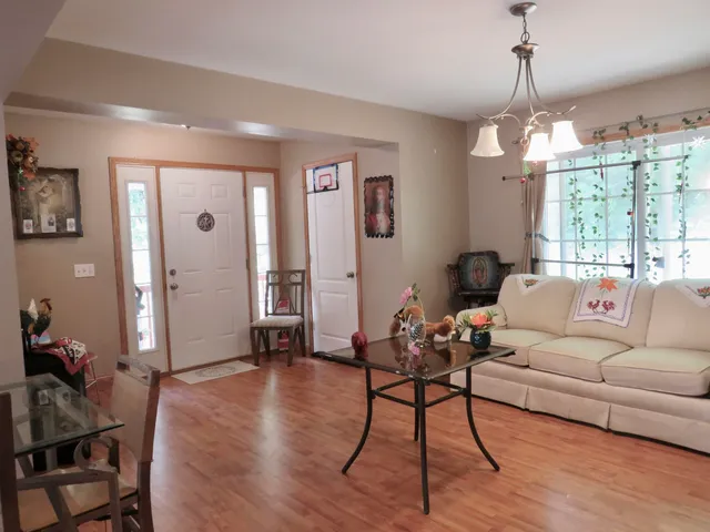 a living room with furniture chandelier and a window