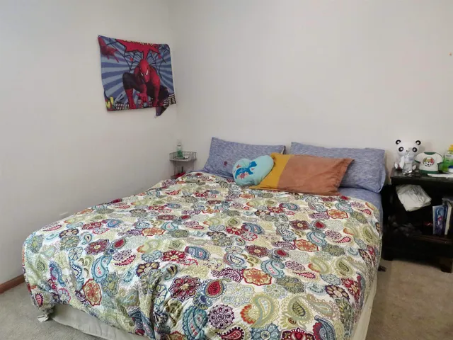 a bedroom with a bed and painting on the wall