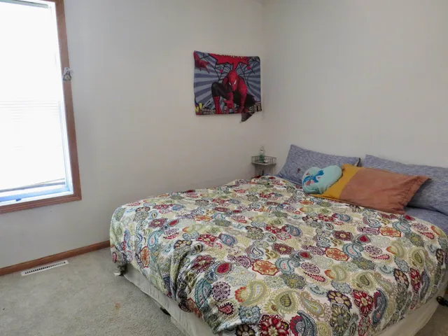 a bed sitting in a bedroom next to a window