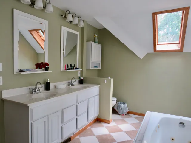 a bathroom with a double vanity sink mirror and bathtub