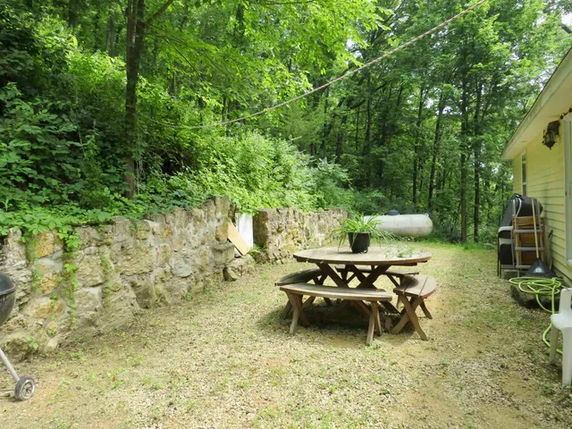 a view of a chair and table in backyard of the house