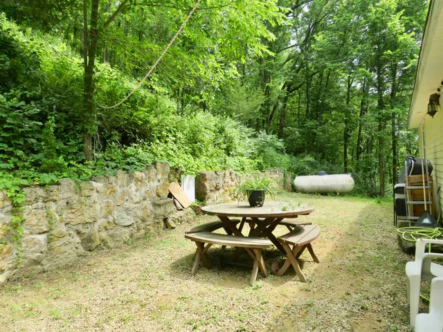 a view of a house with a yard and large tree