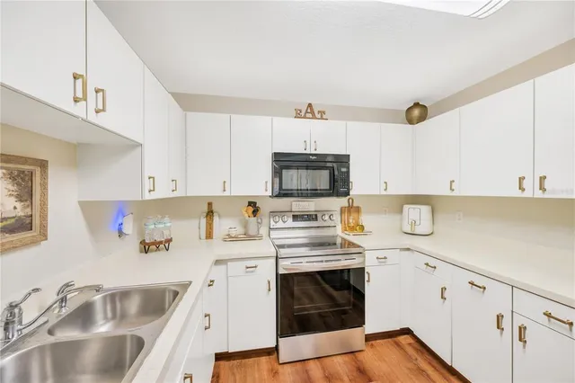 a kitchen with kitchen island a sink a stove and cabinets