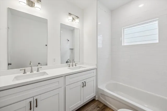 a bathroom with a tub sink and mirror