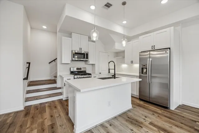 a kitchen with kitchen island a sink stainless steel appliances and cabinets