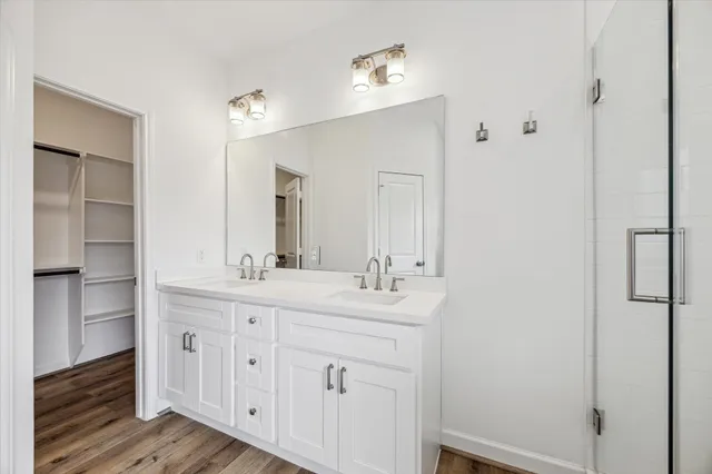 a bathroom with a double vanity sink a mirror and a shower