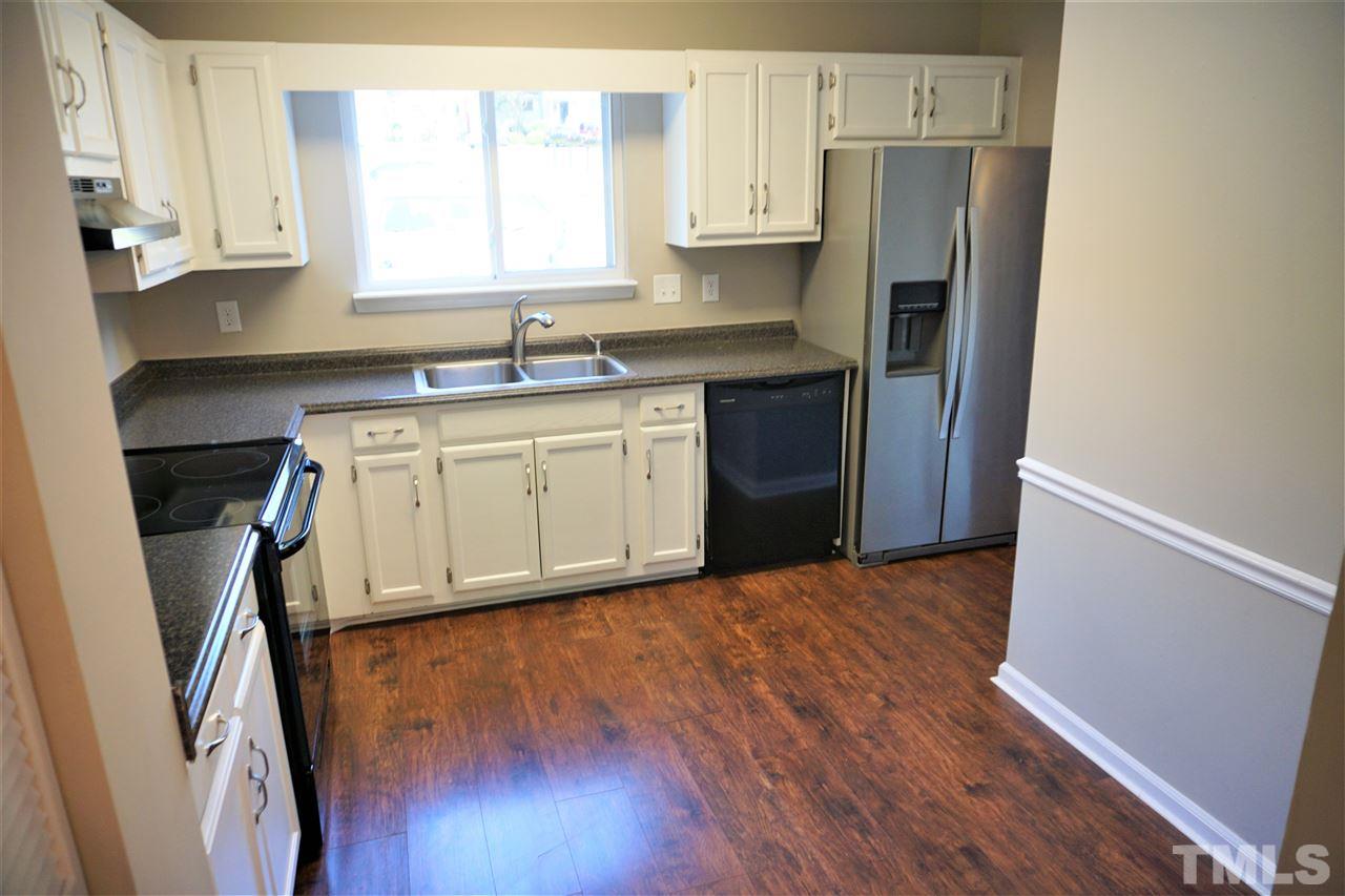 5710 Pool Side Drive Raleigh, NC 27612 - Photo 3 of 6 a kitchen with stainless steel appliances granite countertop a refrigerator a sink a stove a microwave and wooden floors