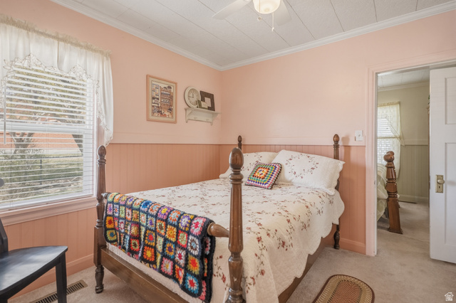 82 South 100 West Lyman, UT 84749 - Photo 20 of 27 Bedroom with a wainscoted wall, ornamental molding, a ceiling fan, and light colored carpet