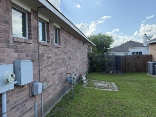 6720 Cromarty Lane Austin, TX 78754 - Photo 5 of 24 A well-maintained side yard offers ample space for outdoor activities and features classic brick construction.