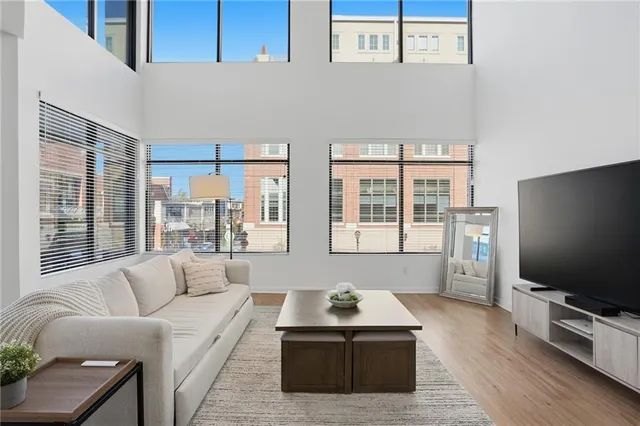 a living room with furniture a flat screen tv and a large window