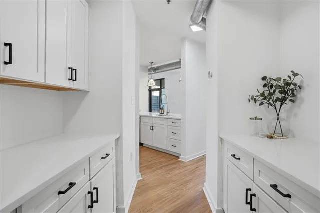 wooden floor with white cabinets and sink