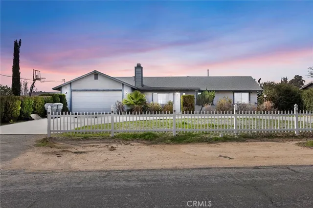 a view of a house with a small yard and fence