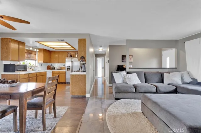 a living room with furniture and a dining table with kitchen view