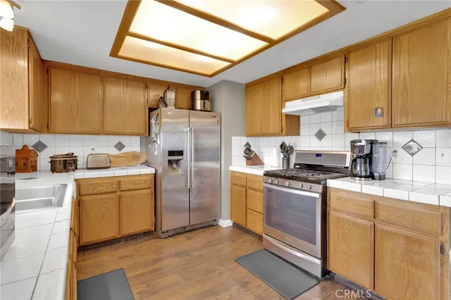 a kitchen with stainless steel appliances granite countertop a stove a sink dishwasher and a refrigerator